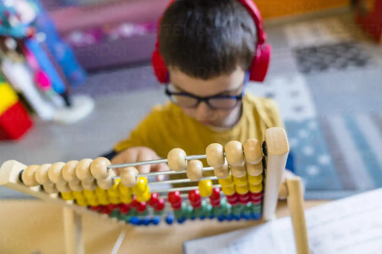 Boy calculating with abacus whil
