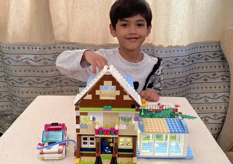 Kid building lego house