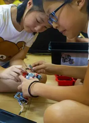 two girl doing lego robotics happily at Advaspire robotics class
