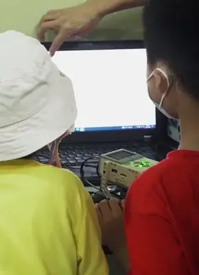 brother and sister learn lego robotics with laptop
