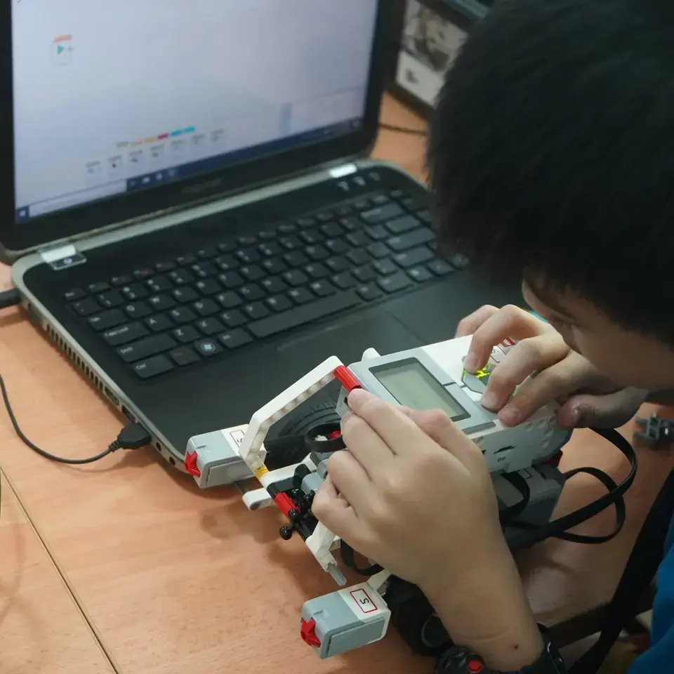 boy kid setting lego robotics kit with laptop